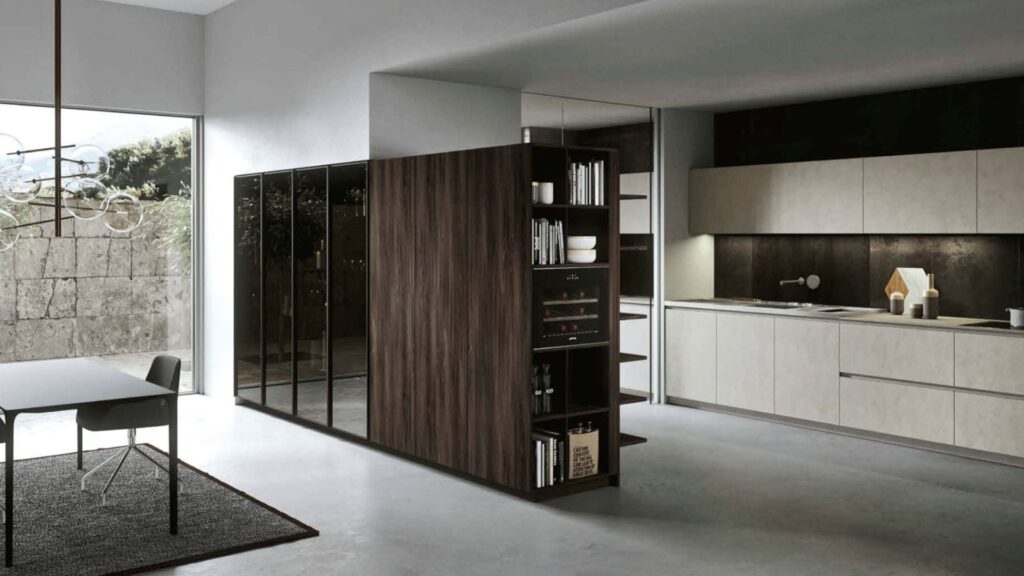 Cocina de diseño moderno con isla de almacenamiento en madera oscura y mobiliario en tonos beige, creada por estudio de diseño en Madrid.