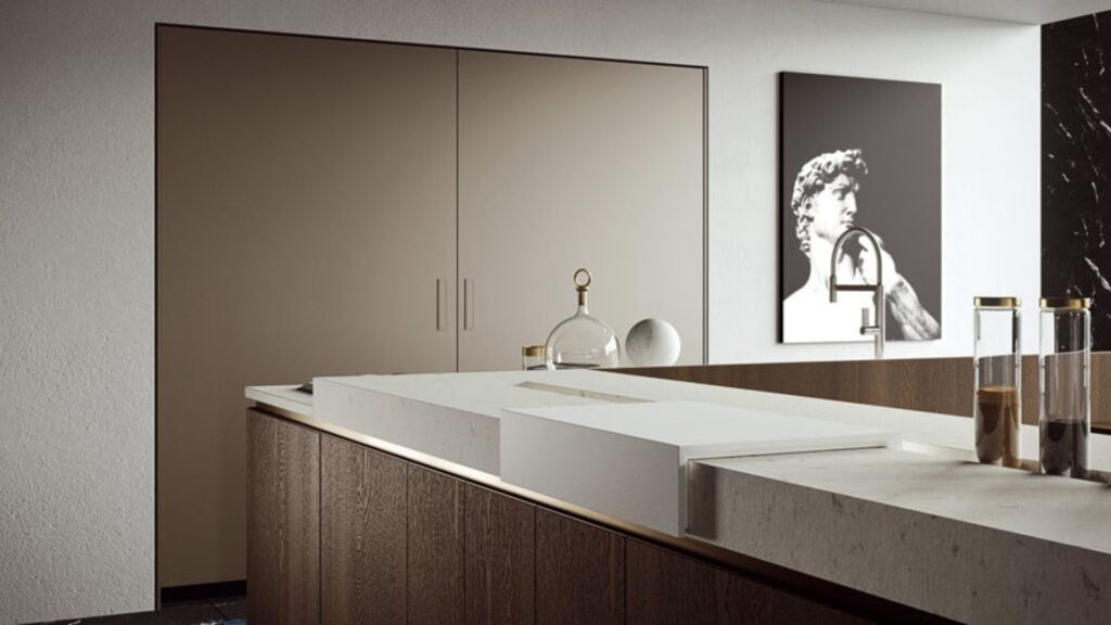 Isla de cocina con encimera de piedra y muebles de madera oscura en un ambiente minimalista.